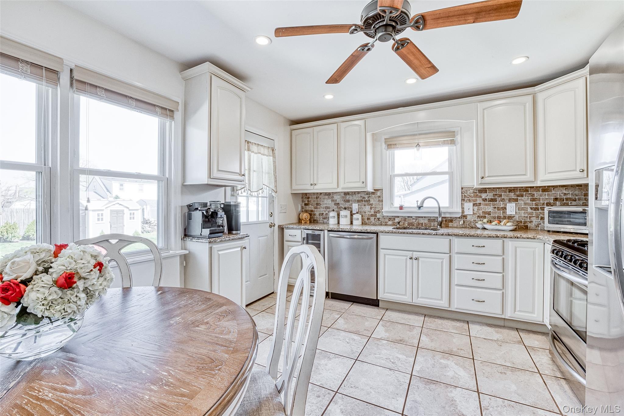 210 11th Street West Babylon, NY 11704 - Photo 14 of 36 a kitchen with granite countertop a sink window and cabinets