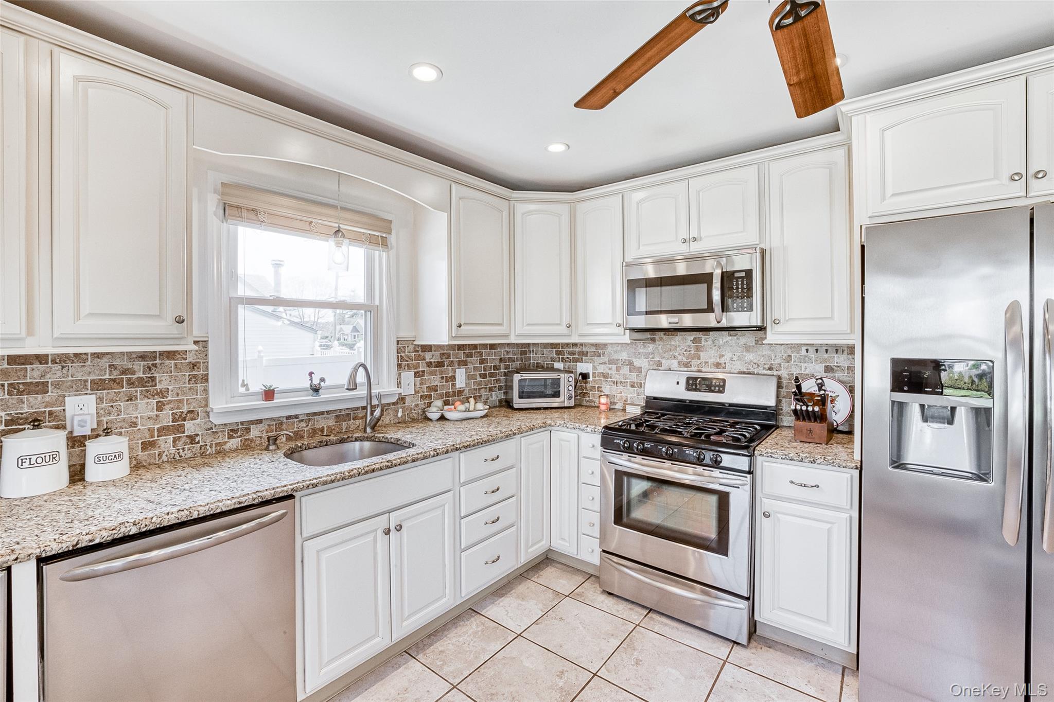 210 11th Street West Babylon, NY 11704 - Photo 2 of 36 a kitchen with cabinets appliances a sink and a window
