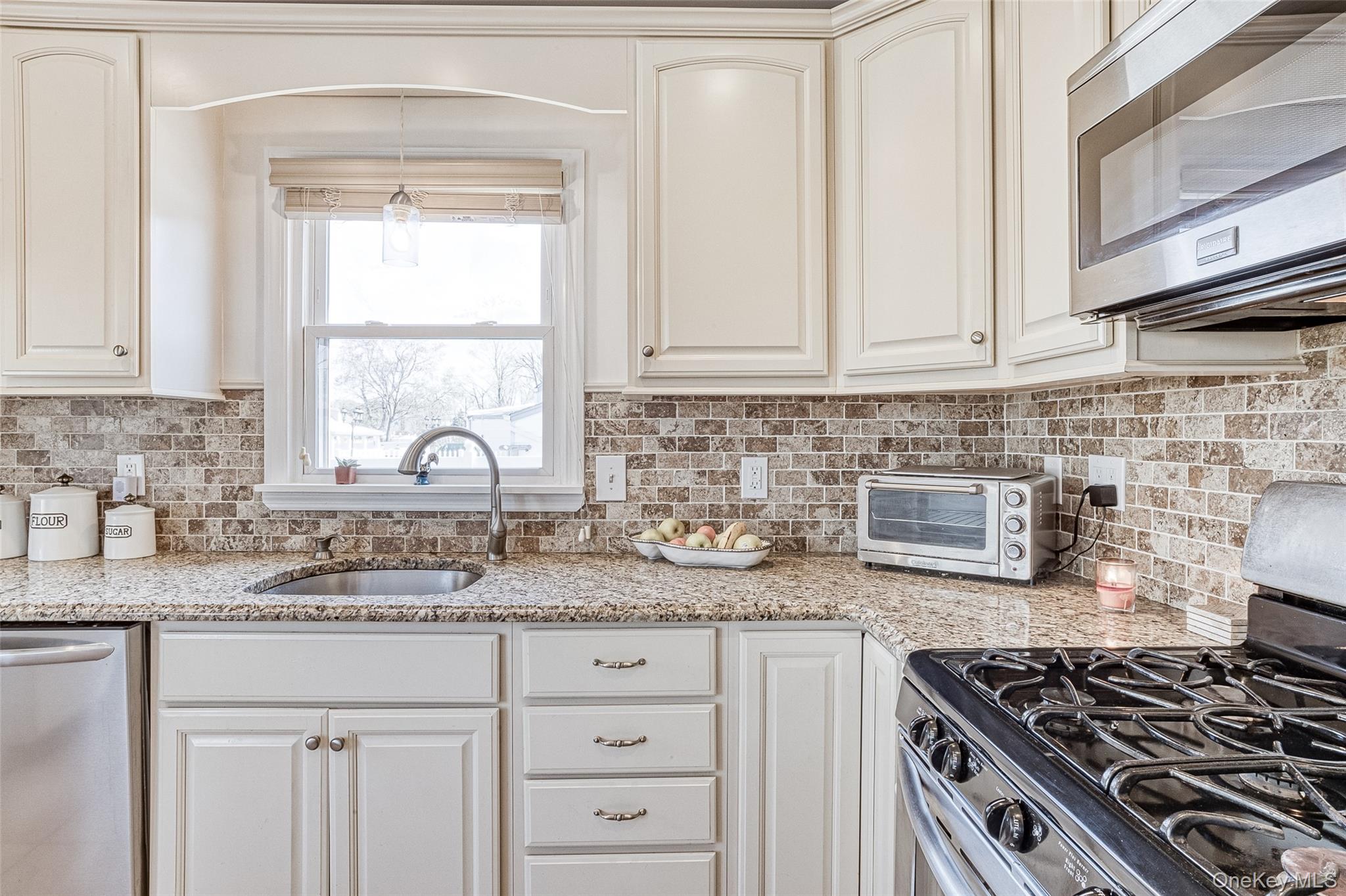 210 11th Street West Babylon, NY 11704 - Photo 3 of 36 a kitchen with granite countertop a stove sink and cabinets