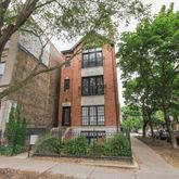a front view of a building with a tree