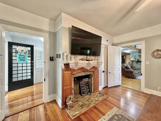 a living room with furniture a flat screen tv and kitchen view