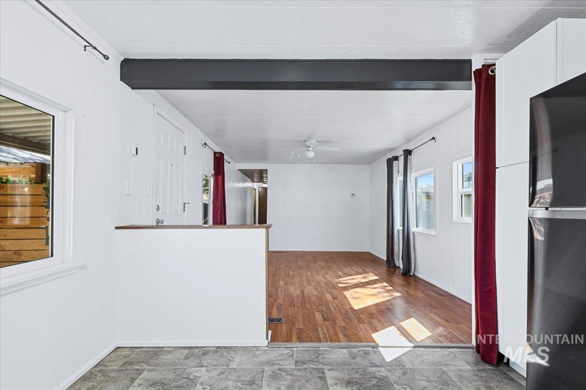 7701 West Ustick Road, Unit 14 Boise, ID 83704 - Photo 11 of 22 Kitchen featuring freestanding refrigerator, beam ceiling, white cabinetry, dark wood-type flooring, and a ceiling fan