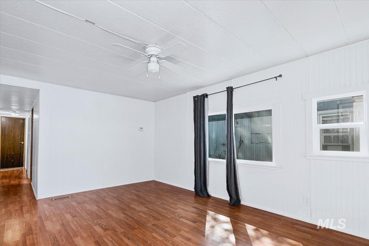 7701 West Ustick Road, Unit 14 Boise, ID 83704 - Photo 13 of 22 Empty room with dark wood-style floors and a ceiling fan