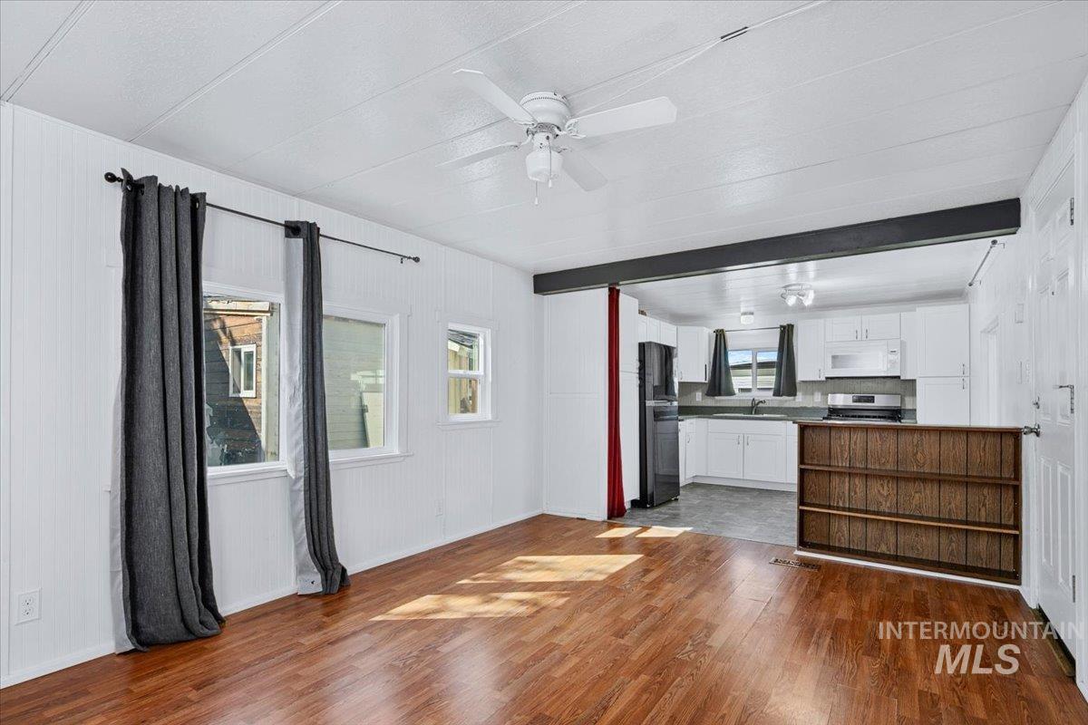 7701 West Ustick Road, Unit 14 Boise, ID 83704 - Photo 15 of 22 Unfurnished living room with dark wood-style floors and a ceiling fan