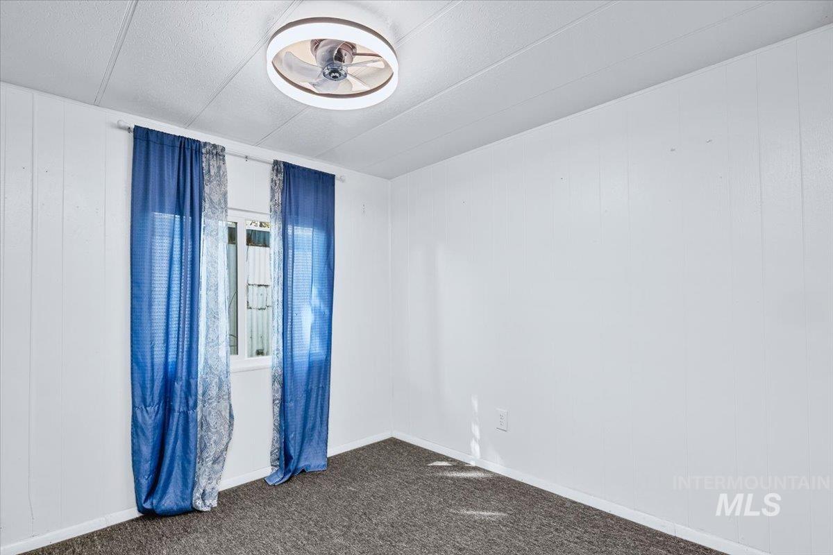 7701 West Ustick Road, Unit 14 Boise, ID 83704 - Photo 16 of 22 Empty room with dark carpet and baseboards