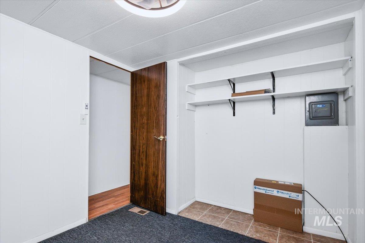 7701 West Ustick Road, Unit 14 Boise, ID 83704 - Photo 17 of 22 Unfurnished bedroom featuring wood walls and a closet