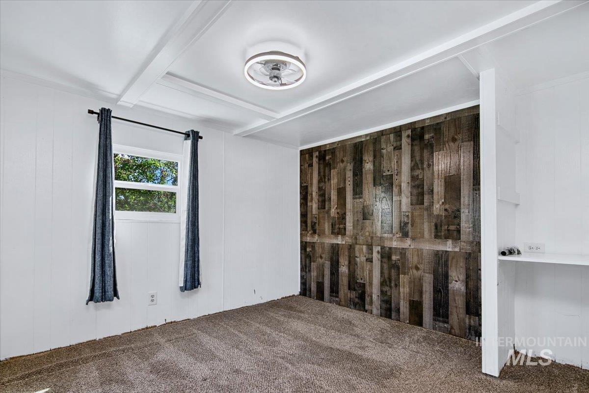 7701 West Ustick Road, Unit 14 Boise, ID 83704 - Photo 20 of 22 Unfurnished bedroom with wooden walls, beam ceiling, and carpet floors
