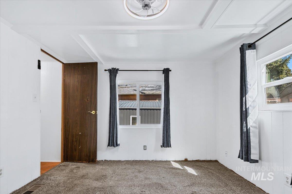 7701 West Ustick Road, Unit 14 Boise, ID 83704 - Photo 22 of 22 Spare room featuring carpet flooring and wooden walls