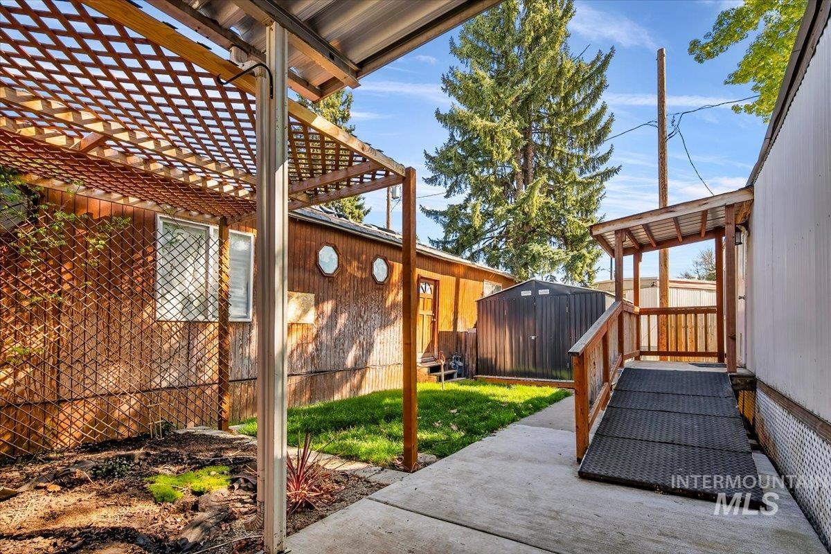 7701 West Ustick Road, Unit 14 Boise, ID 83704 - Photo 5 of 22 Fenced backyard featuring a storage unit and a pergola