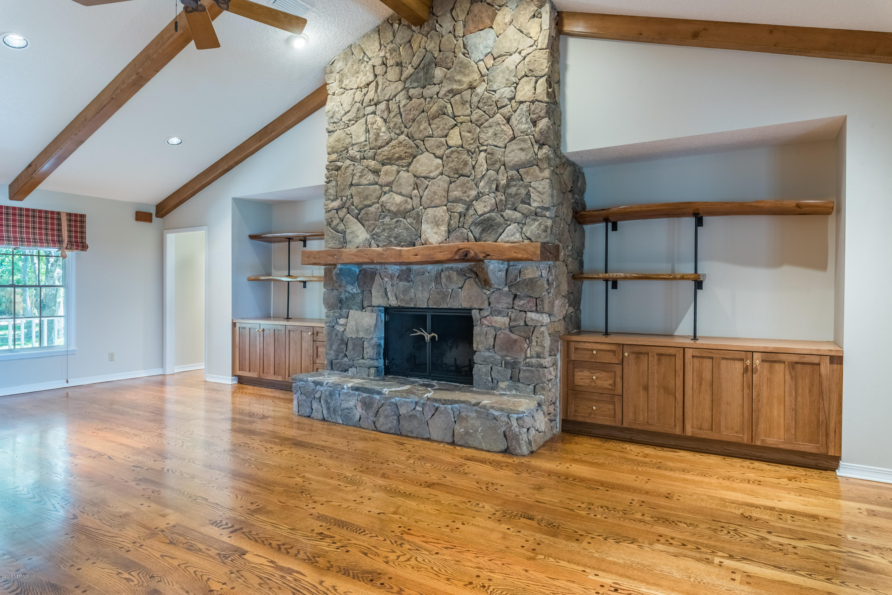7867 Rusty Anchor Road St. Augustine, FL 32092 - Photo 15 of 36 a view of a livingroom with wooden floor and a fireplace