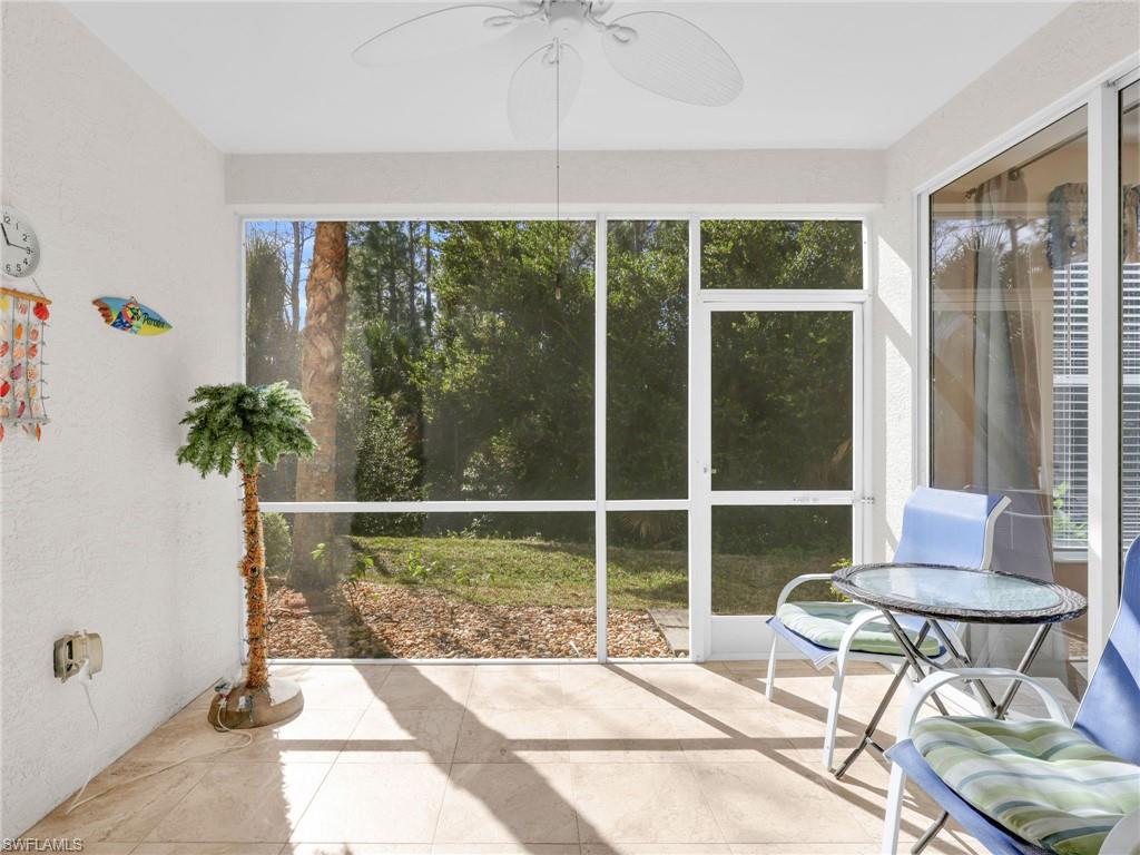 1435 Tiffany Lane, Unit 302 Naples, FL 34105 - Photo 16 of 36 a living room with a floor to ceiling window and potted plant