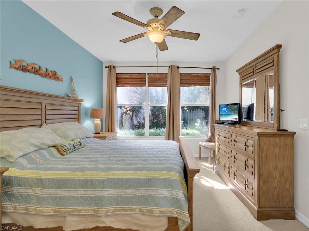 1435 Tiffany Lane, Unit 302 Naples, FL 34105 - Photo 20 of 36 a bedroom with a large bed and a large window with the outer view