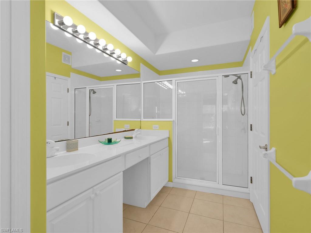 1435 Tiffany Lane, Unit 302 Naples, FL 34105 - Photo 22 of 36 a bathroom with a tub sink and mirror