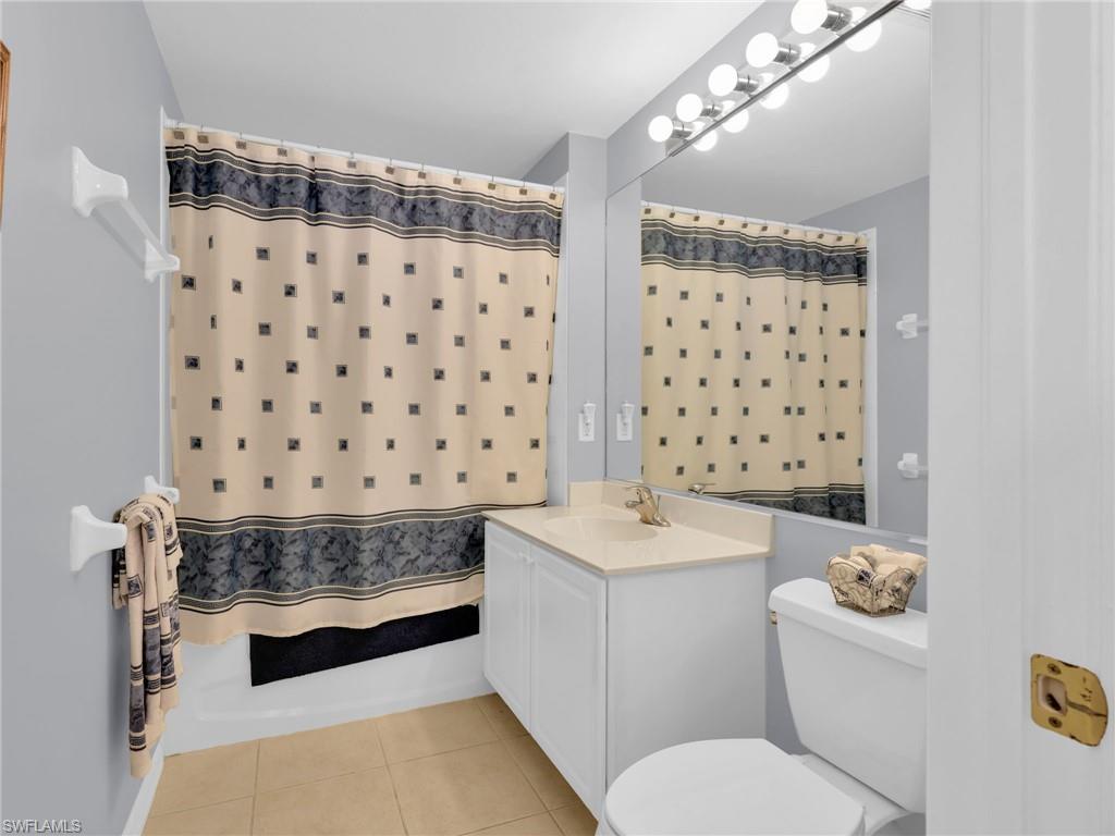 1435 Tiffany Lane, Unit 302 Naples, FL 34105 - Photo 25 of 36 a spacious bathroom with a double vanity sink toilet and shower