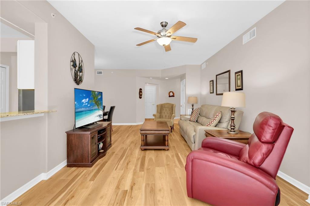 1435 Tiffany Lane, Unit 302 Naples, FL 34105 - Photo 4 of 36 a living room with furniture a flat screen tv and a window