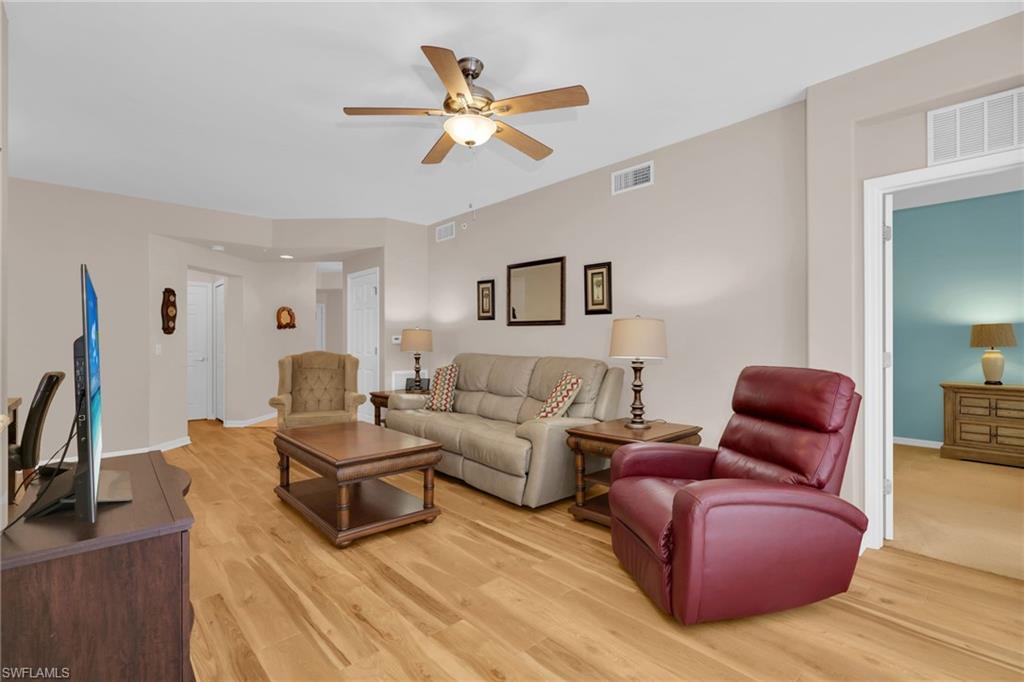 1435 Tiffany Lane, Unit 302 Naples, FL 34105 - Photo 6 of 36 a living room with furniture a ceiling fan and a rug