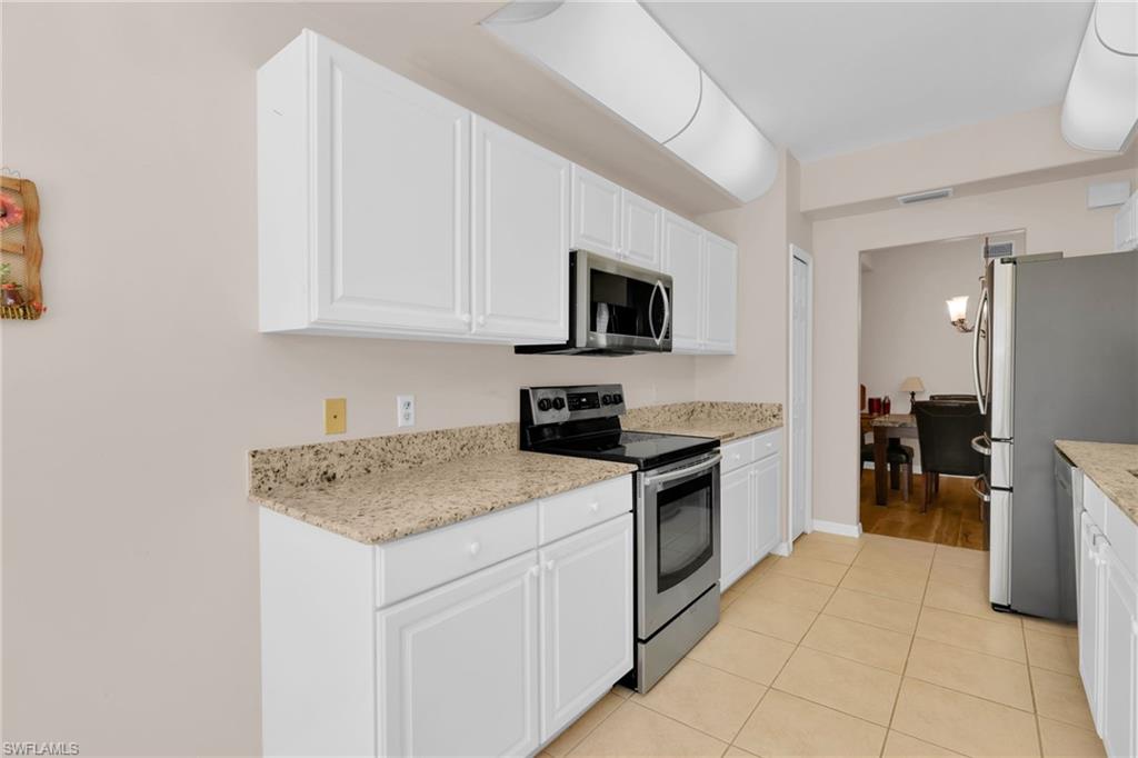 1435 Tiffany Lane, Unit 302 Naples, FL 34105 - Photo 10 of 36 a kitchen with a sink stove and cabinets