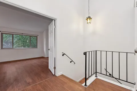 a view of a hallway with wooden floor and closet