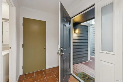 a view of a hallway with wooden floor and a bathroom