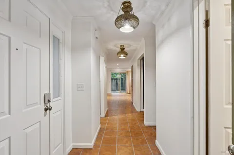 a view of a hallway with wooden floor