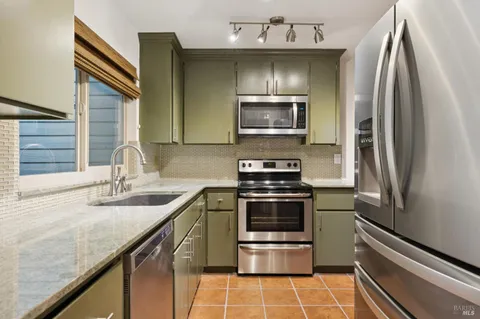 a kitchen with stainless steel appliances a sink stove and refrigerator
