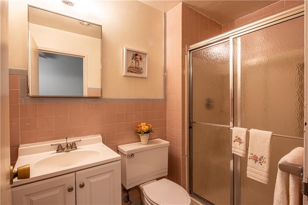 112 Washington Place, Unit 2F Pittsburgh, PA 15219 - Photo 17 of 30 a bathroom with a toilet sink and mirror