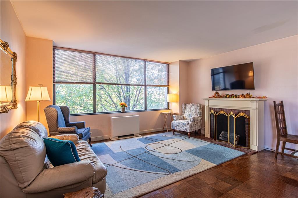 112 Washington Place, Unit 2F Pittsburgh, PA 15219 - Photo 6 of 30 a living room with furniture a flat screen tv and a fireplace