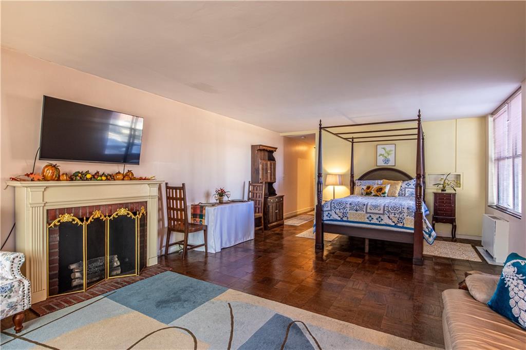 112 Washington Place, Unit 2F Pittsburgh, PA 15219 - Photo 9 of 30 a living room with furniture a fireplace and a flat screen tv