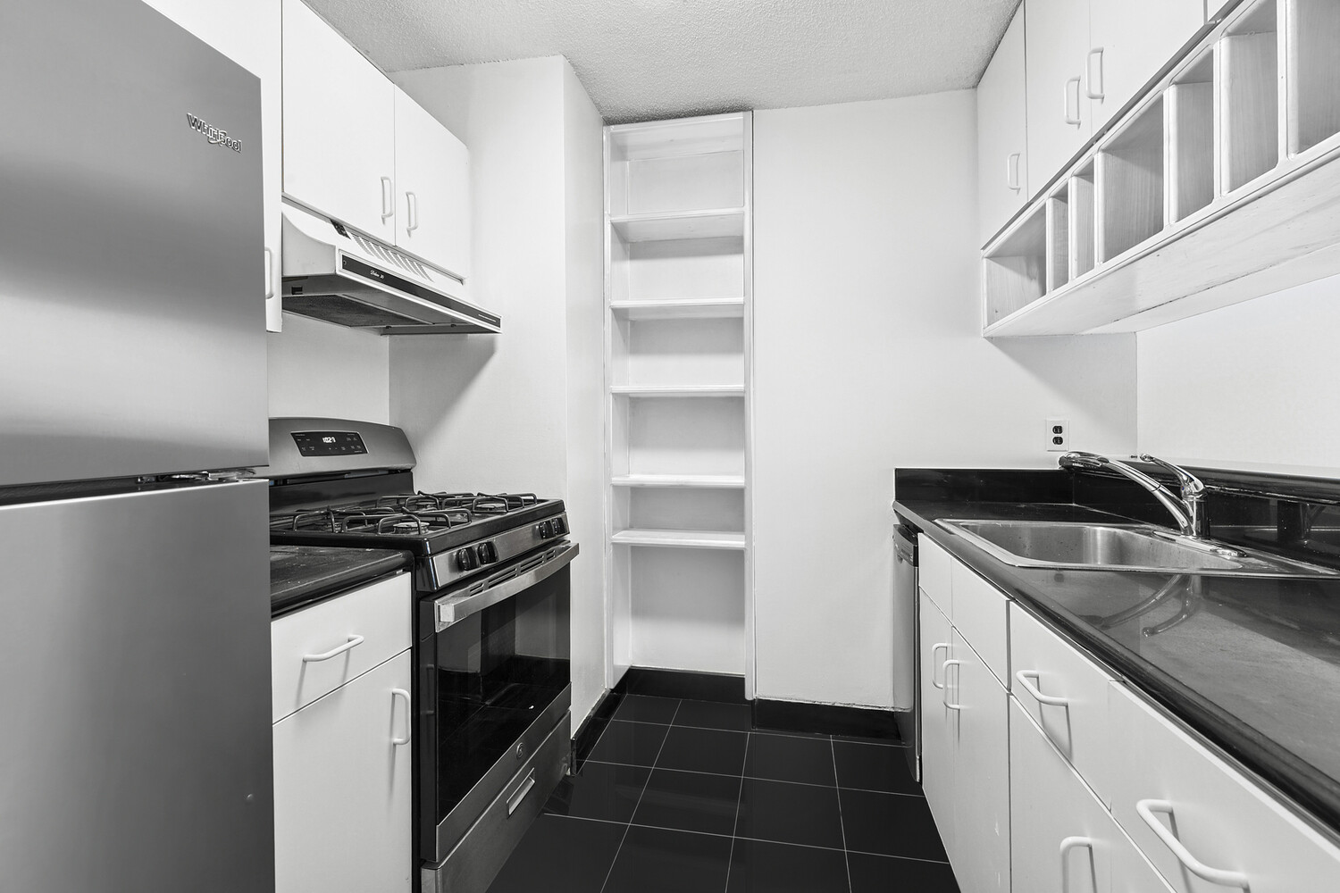 376 Broadway, Unit 10G Manhattan, NY 10013 - Photo 3 of 4 a kitchen with granite countertop a sink stove and cabinets