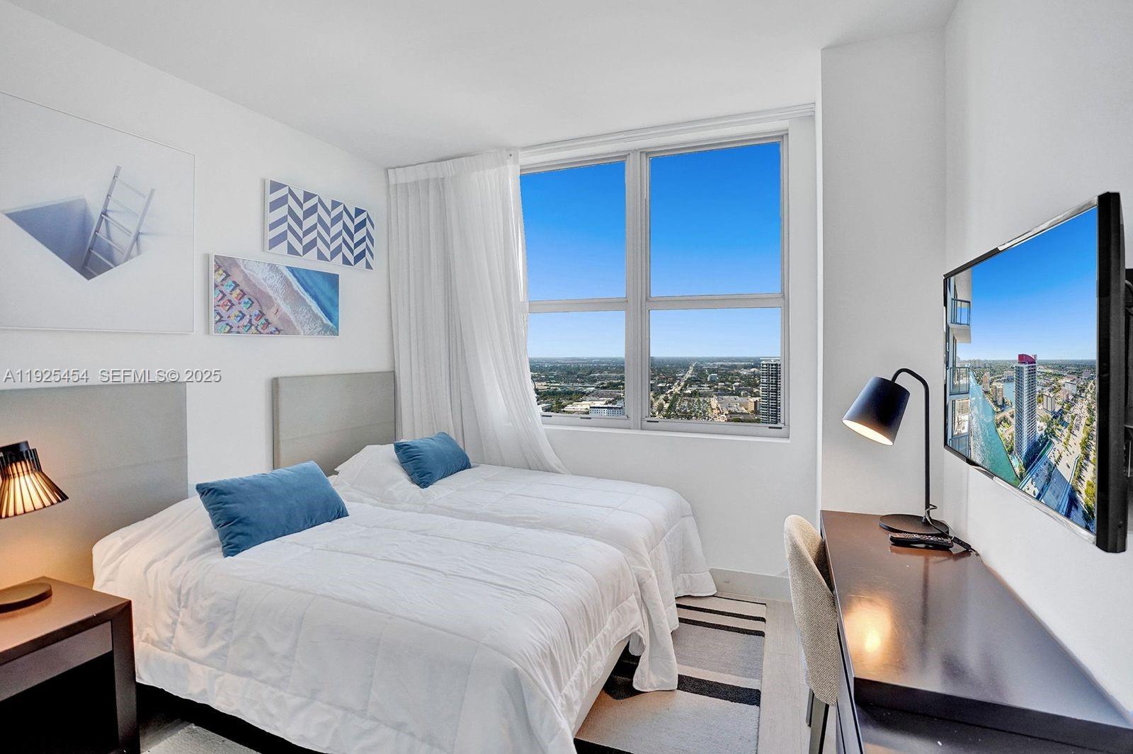 4010 South Ocean Drive, Unit R1108 Hollywood, FL 33019 - Photo 13 of 30 a bedroom with a bed and a large window