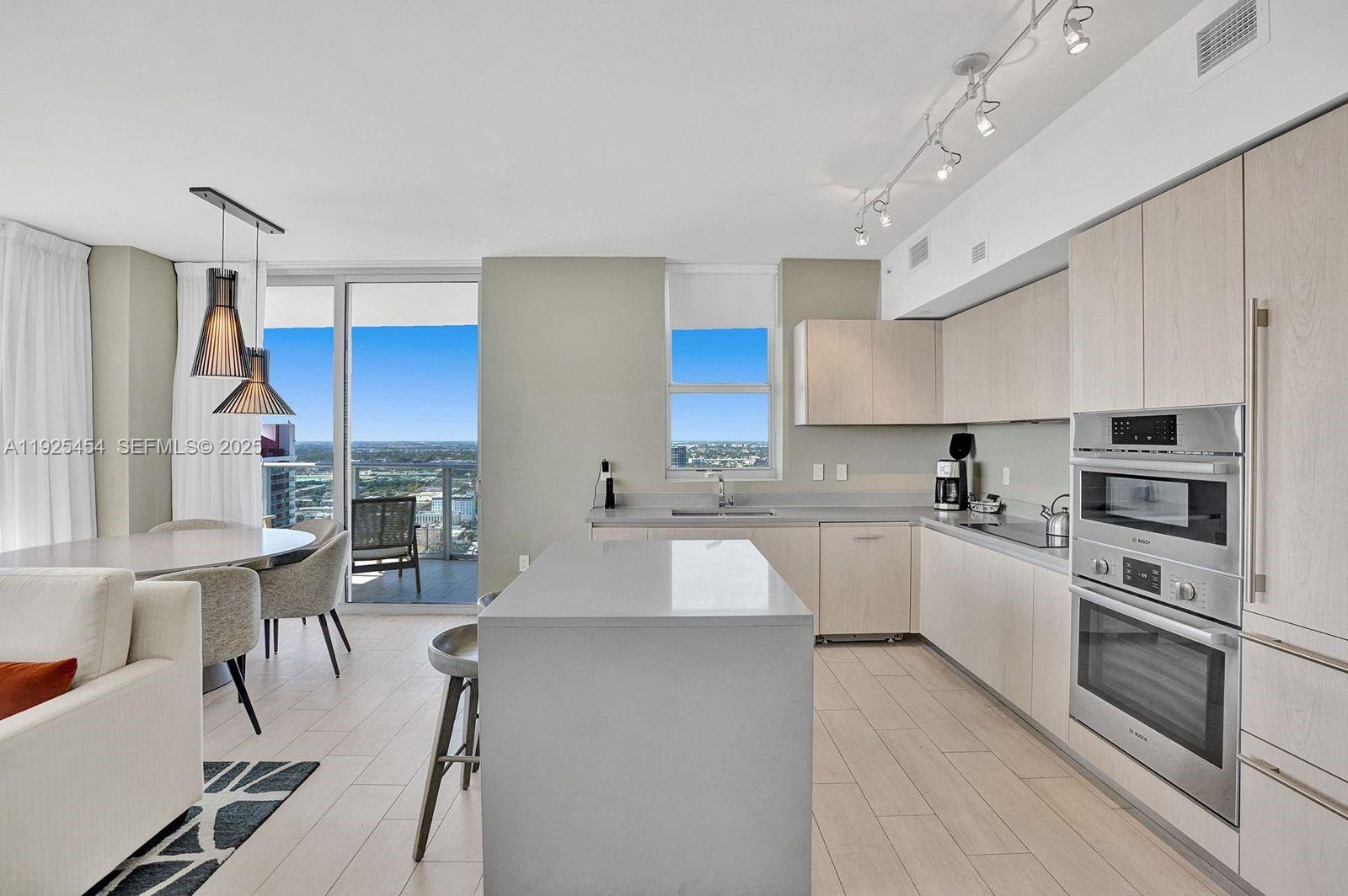 4010 South Ocean Drive, Unit R1108 Hollywood, FL 33019 - Photo 24 of 30 a kitchen with a sink a counter top space stainless steel appliances and cabinets