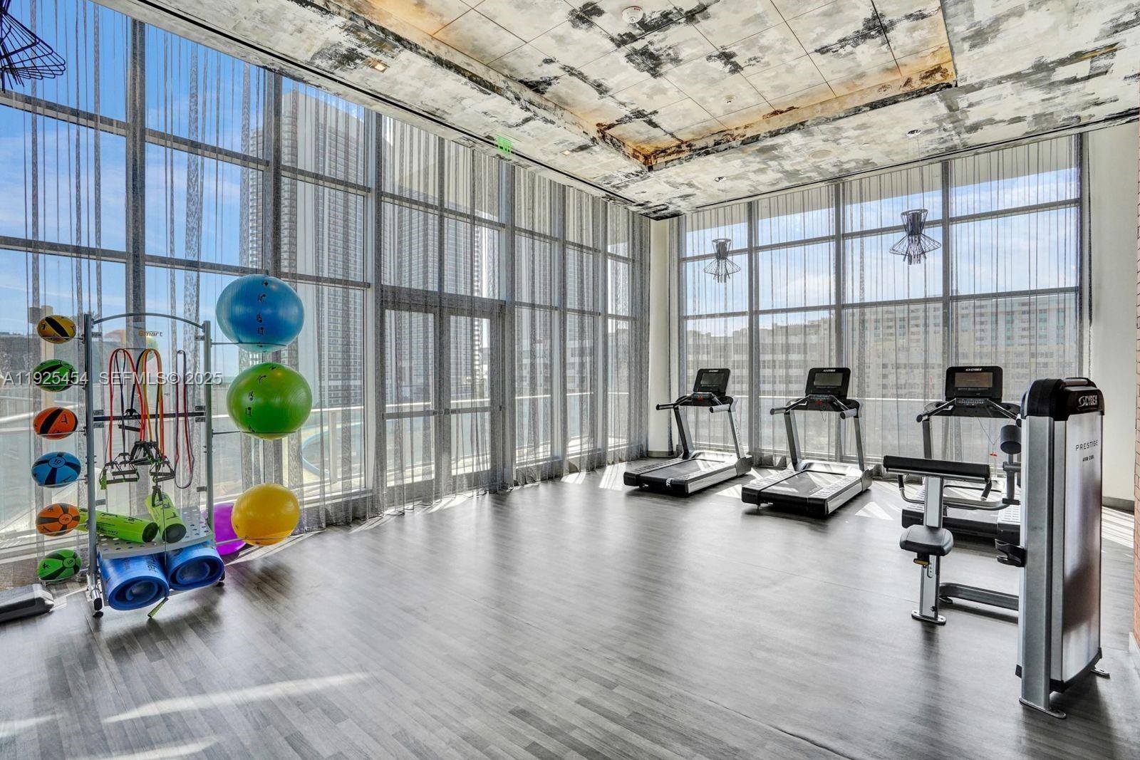 4010 South Ocean Drive, Unit R1108 Hollywood, FL 33019 - Photo 25 of 30 a room with gym equipment and a large window