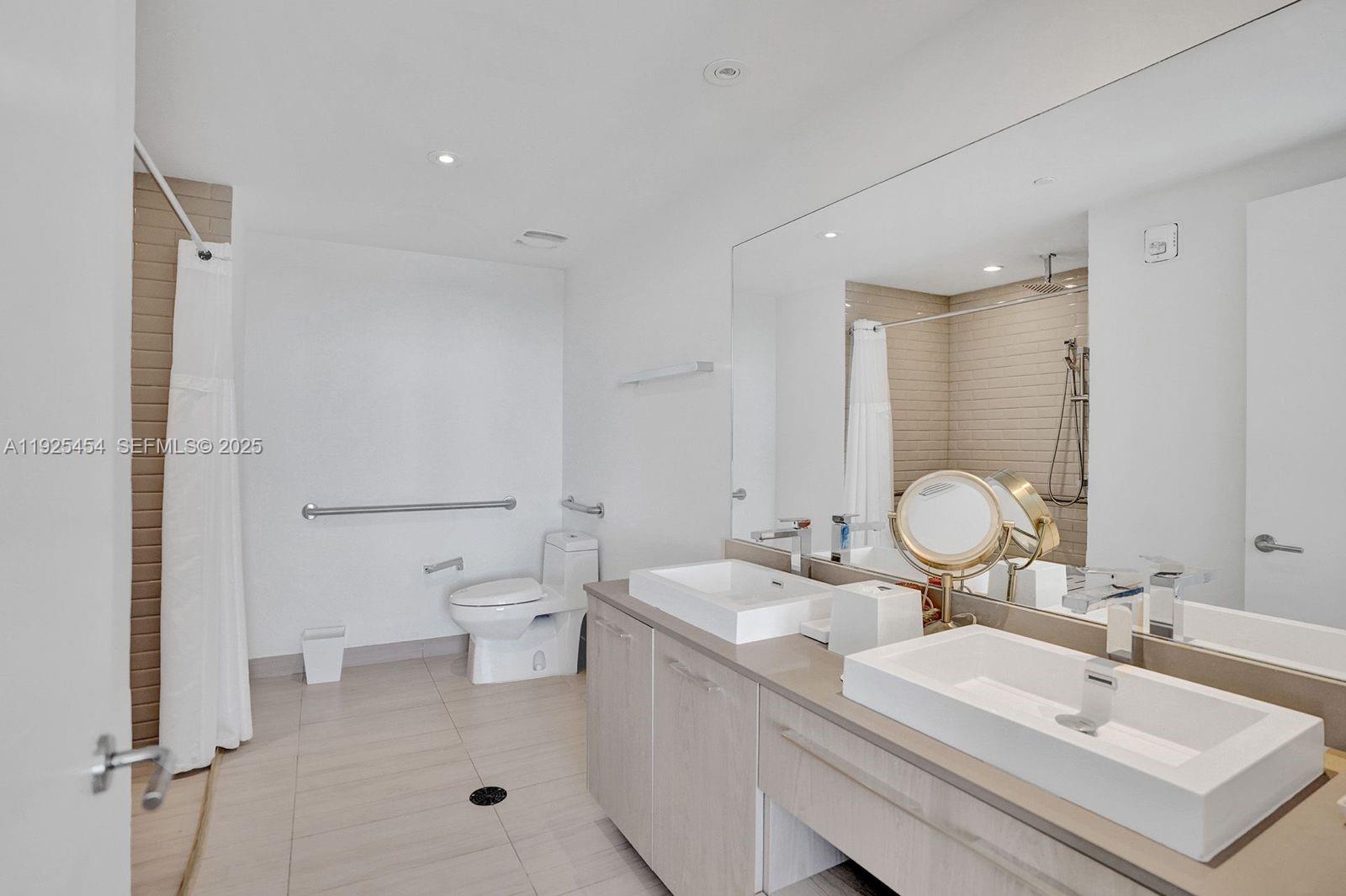 4010 South Ocean Drive, Unit R1108 Hollywood, FL 33019 - Photo 29 of 30 a bathroom with a double vanity sink mirror and toilet