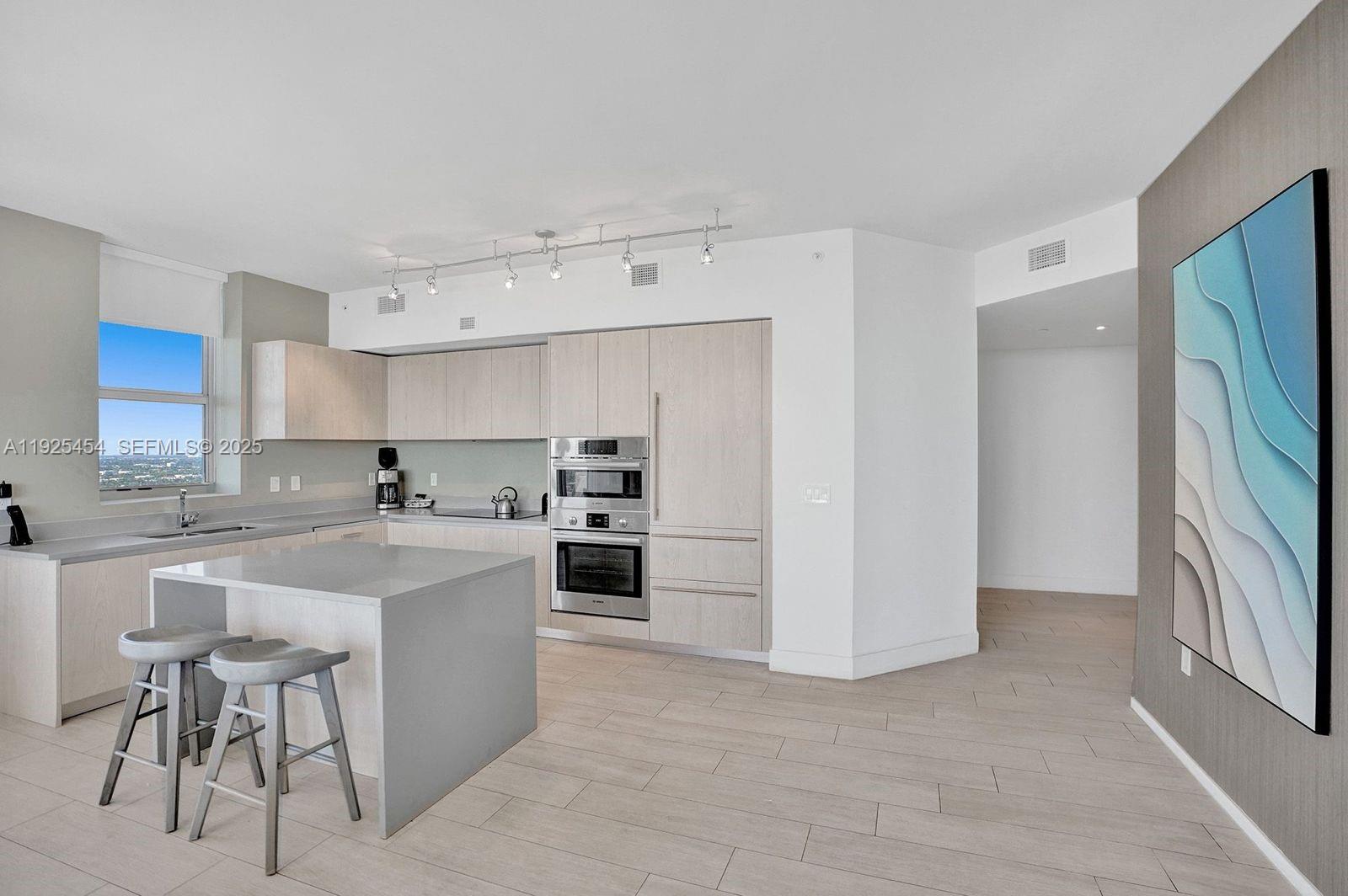 4010 South Ocean Drive, Unit R1108 Hollywood, FL 33019 - Photo 6 of 30 a kitchen with stainless steel appliances a sink a stove a refrigerator and cabinets