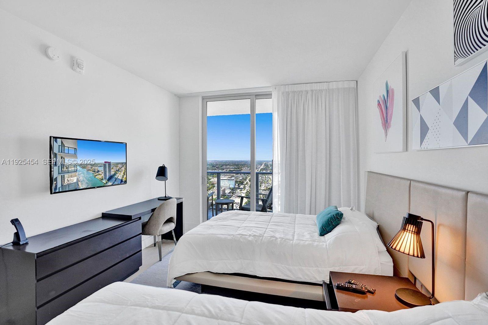 4010 South Ocean Drive, Unit R1108 Hollywood, FL 33019 - Photo 10 of 30 a spacious bedroom with a bed and a desk