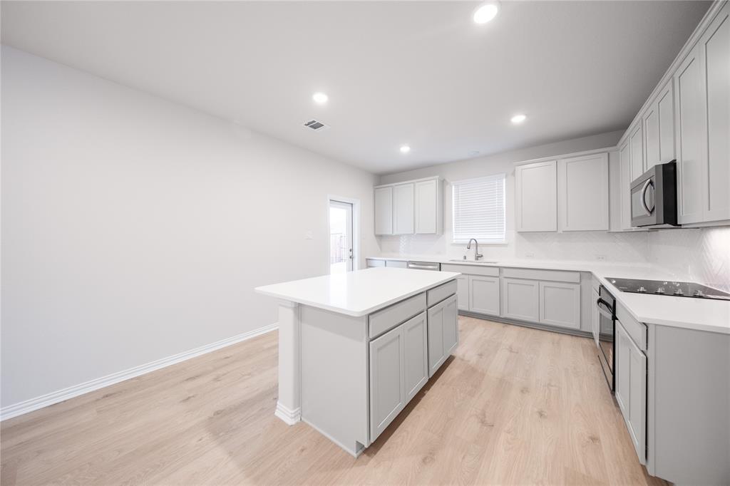 2606 Hawkins Street Anna, TX 75409 - Photo 13 of 31 a kitchen with a sink cabinets and wooden floor