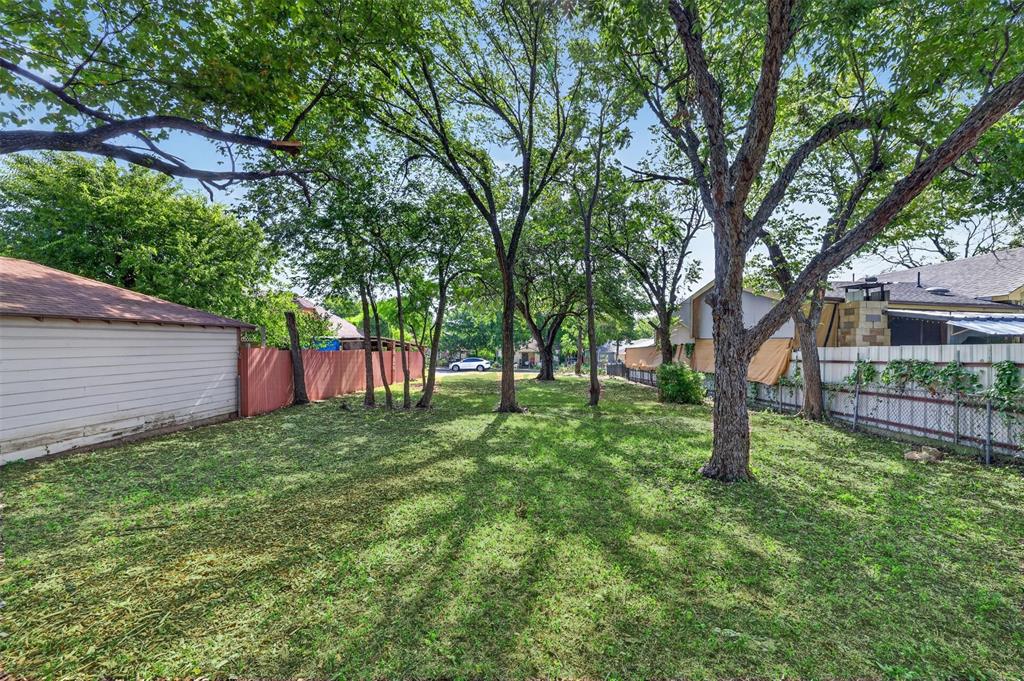 6 North Ravinia Drive Dallas, TX 75211 - Photo 6 of 12 Expansive backyard featuring mature trees providing ample shade, a manicured lawn, and perimeter fencing