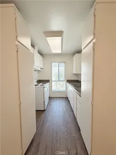 a kitchen with a white refrigerator freezer a stove top oven a sink and dishwasher