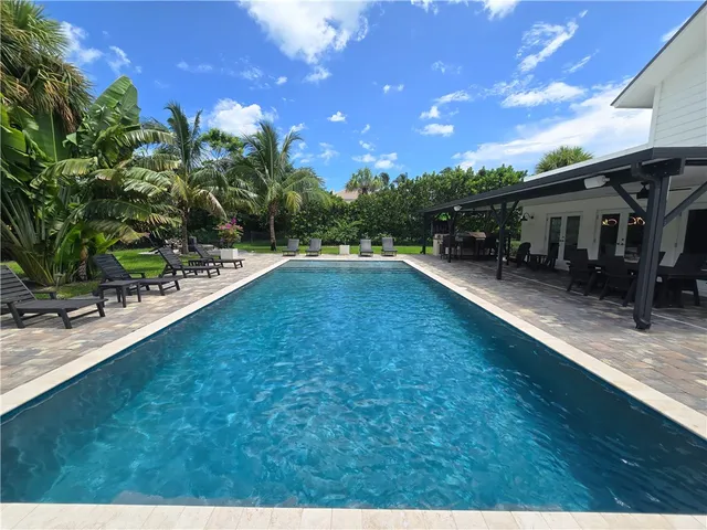 a swimming pool with outdoor seating and yard