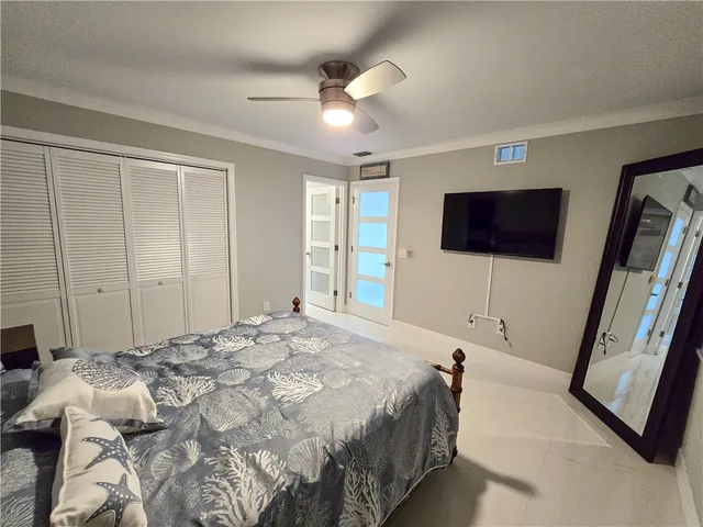 a spacious bedroom with a bed and a flat screen tv