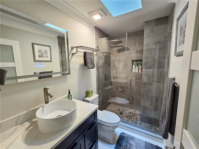a bathroom with a sink toilet a mirror and shower