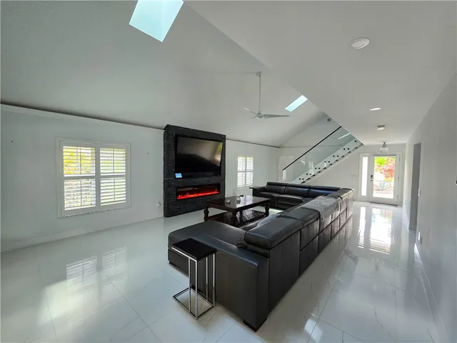 a living room with furniture a flat screen tv and a window