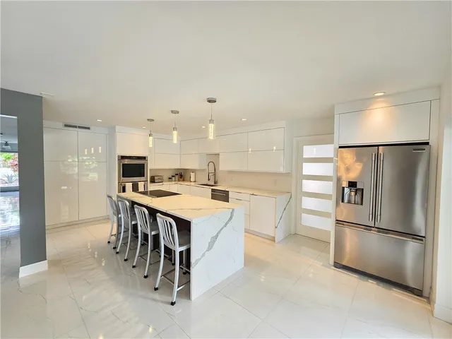 a kitchen with a refrigerator a kitchen island a stove and a refrigerator