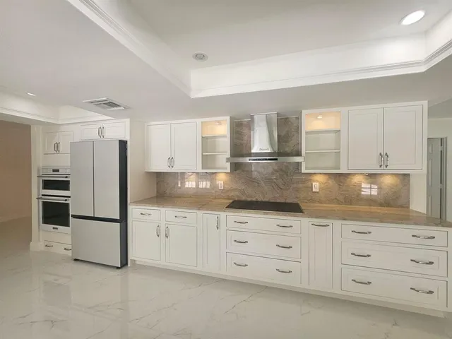 a kitchen with granite countertop a refrigerator and cabinets