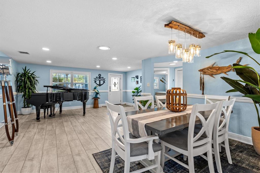 4387 6th Isle Drive Hernando Beach, FL 34607 - Photo 12 of 89 a view of a dining room and livingroom with furniture wooden floor a chandelier