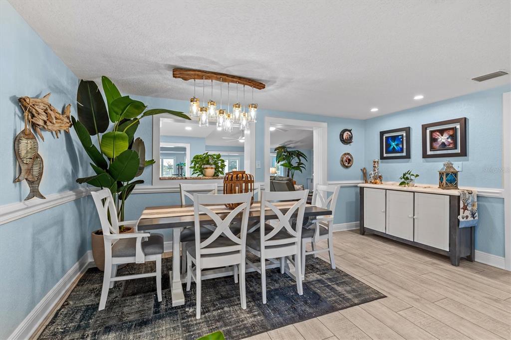 4387 6th Isle Drive Hernando Beach, FL 34607 - Photo 13 of 89 a view of a dining room with furniture a kitchen and chandelier