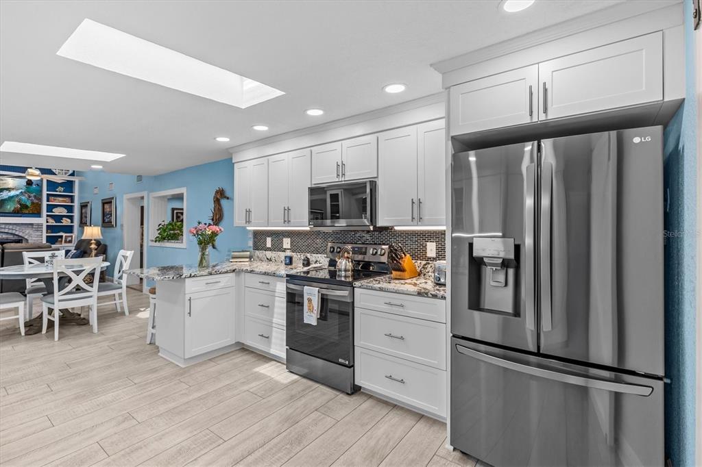 4387 6th Isle Drive Hernando Beach, FL 34607 - Photo 20 of 98 a kitchen with white cabinets and stainless steel appliances