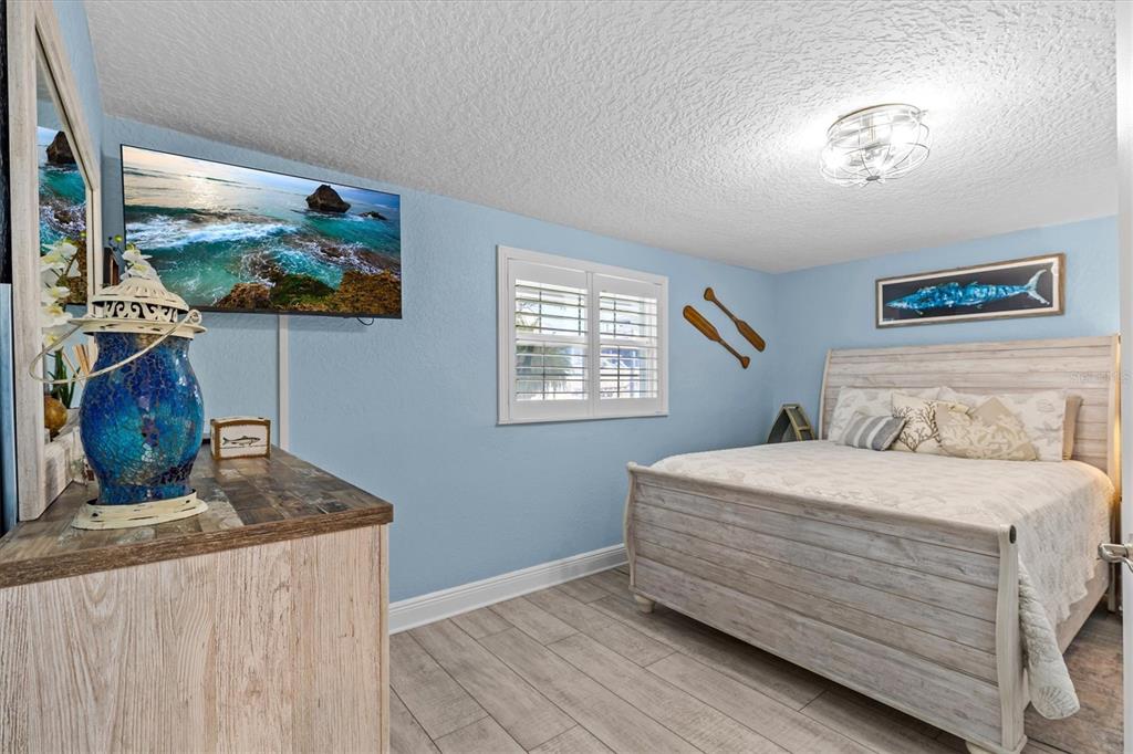 4387 6th Isle Drive Hernando Beach, FL 34607 - Photo 56 of 98 a bedroom with a bed and a painting on the wall