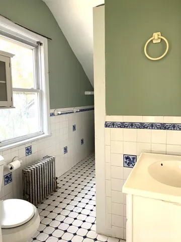 a bathroom with a sink a toilet and a window