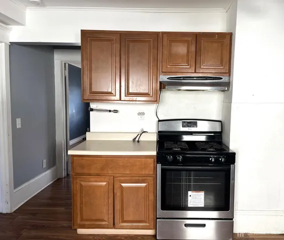 a kitchen with granite countertop cabinets stainless steel appliances and wooden floor